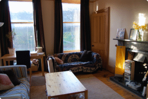 Cozy living room in a low-income apartment with natural light and simple decor.